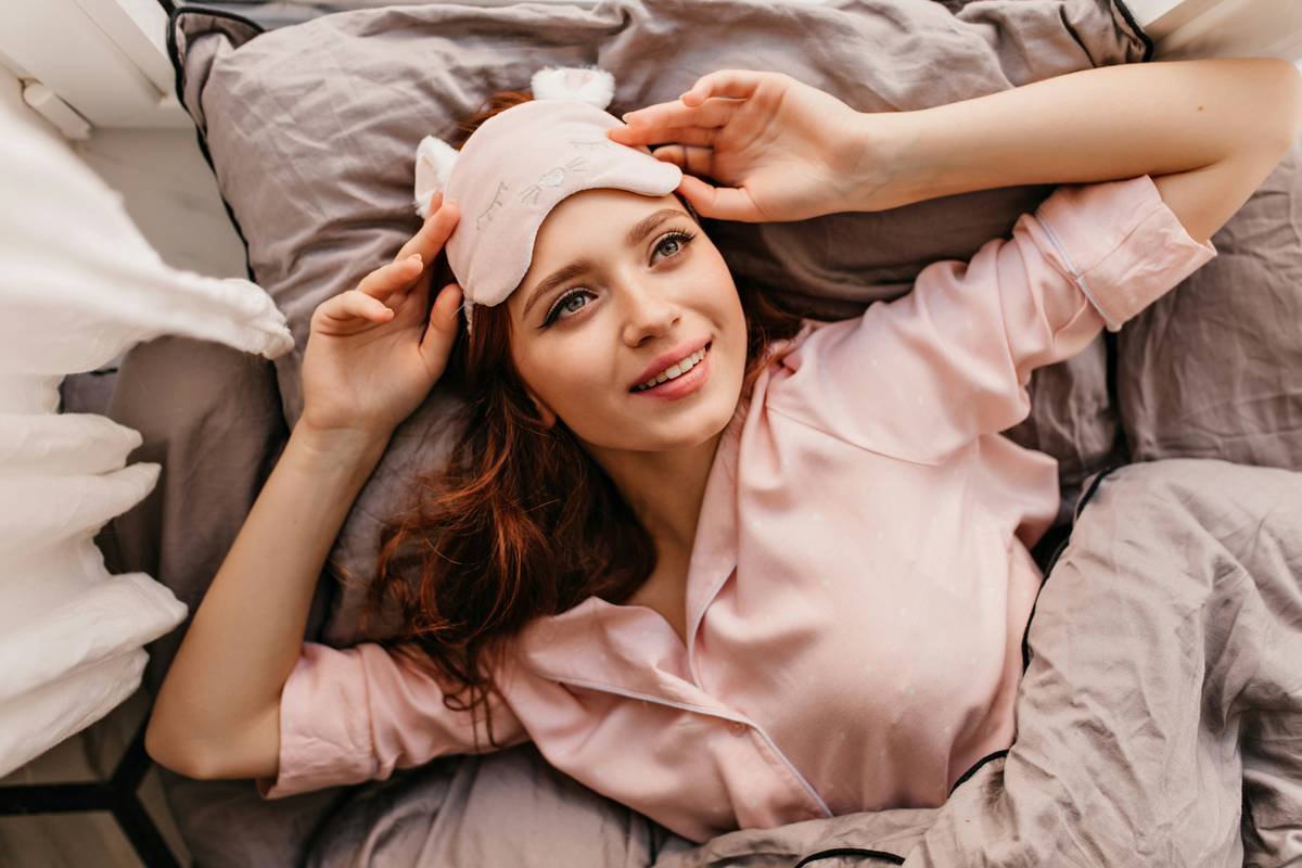 Woman wearing a high-quality nighttime hair shield made of breathable silk to protect curls while sleeping