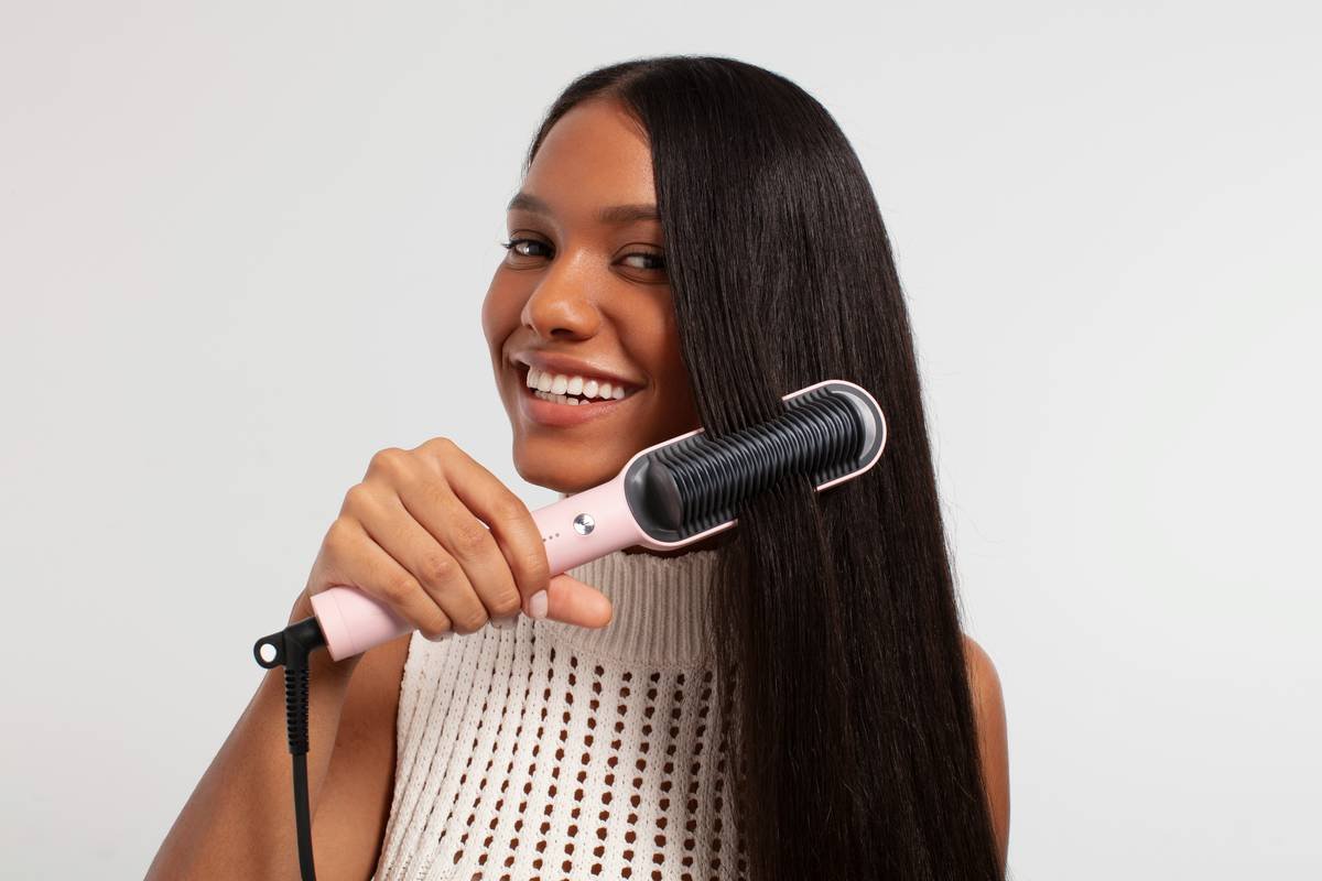 Woman applying hair nourishing gel to damp curls before securing with a satin hair cap